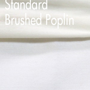 Puede incluir: Primer plano de una tela blanca con el texto "Standard Brushed Poplin" impreso en ella. La tela tiene una textura suave y cepillada.