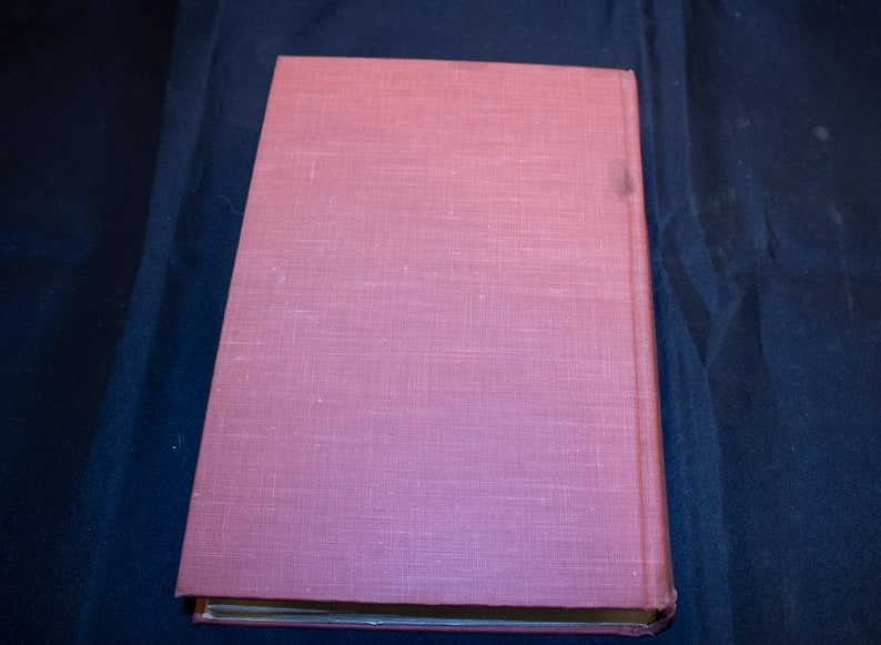 May include: A pink hardcover book with a textured linen cover.