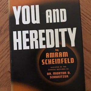 May include: A black and orange book cover with the title "You and Heredity" by Amram Scheinfeld. The book cover also includes the text "Assisted in the genetic sections by Dr. Morton D. Schweitzer."