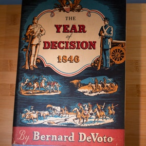 May include: A vintage book cover with a blue background and a red, white, and blue eagle illustration. The title is "The Year of Decision 1846" by Bernard DeVoto. The cover features illustrations of historical scenes.