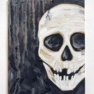 May include: A white skull with black eyes painted on a dark background with black and gray brushstrokes.
