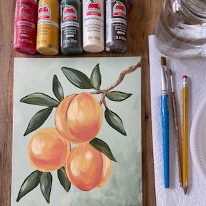May include: An acrylic painting of peaches on a light green background. The painting is accompanied by paint bottles in red, yellow, green, off-white, and brown, along with paintbrushes, a pencil, and a jar of water. The painting is signed.