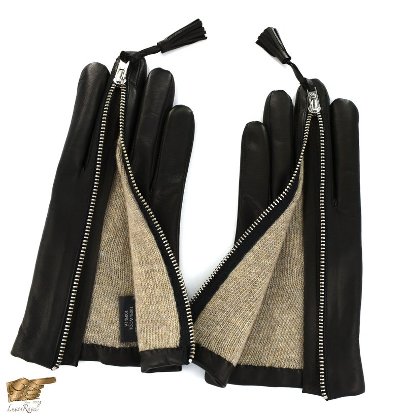 May include: Black leather gloves with a zipper detail and a brown wool lining. The gloves have a tassel on each wrist.