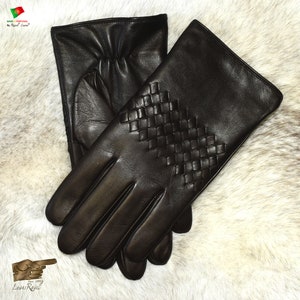May include: A pair of brown leather gloves with a woven pattern on the back of the hand. The gloves are made in Portugal by a company called "Luvas Royal".