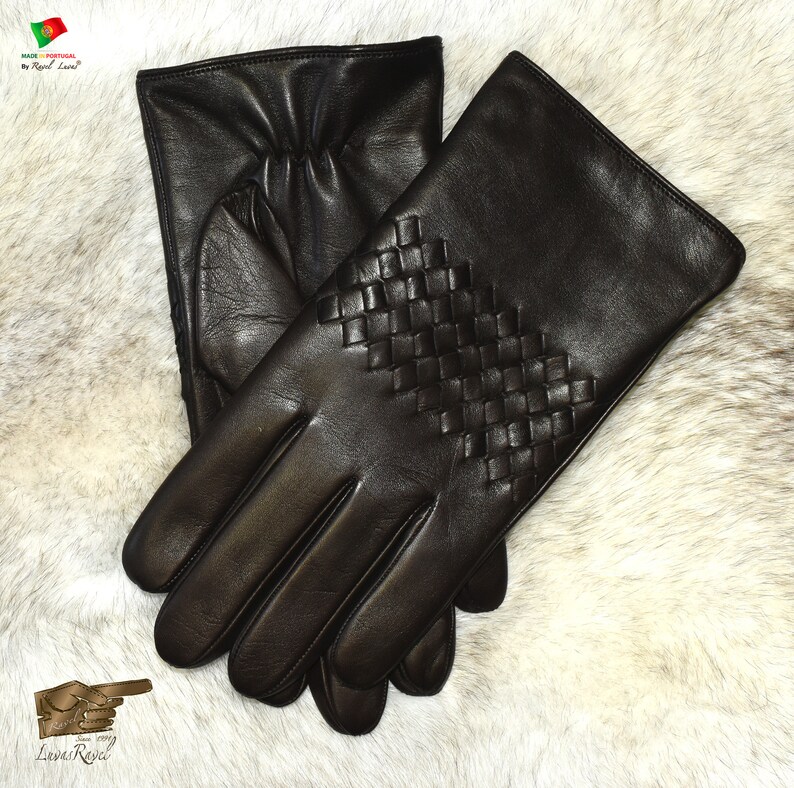 May include: A pair of brown leather gloves with a woven pattern on the back of the hand. The gloves are made in Portugal by a company called "Luvas Royal".