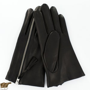 May include: A pair of black leather gloves with a zipper detail on one glove and a tassel on the other. The gloves are made of soft, supple leather and have a classic design.