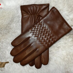 May include: A pair of brown leather gloves with a woven pattern on the back of the hand.
