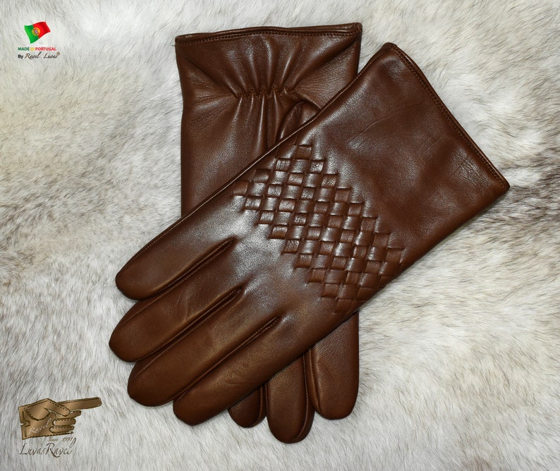May include: A pair of brown leather gloves with a woven pattern on the back of the hand.