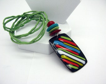 A long, colorful necklace with a large enamelled pendant, stiff design