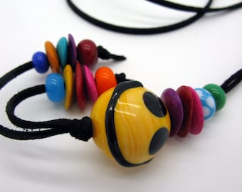 A long, colorful necklace with a large handcrafted lampwork grinning ball, happy colorful chain, a smile to go