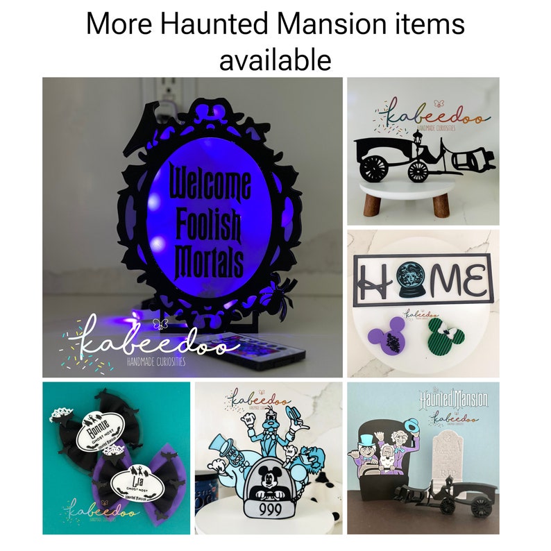 May include: A collection of Haunted Mansion-themed items. Includes a black framed sign with the text "Welcome Foolish Mortals" illuminated with blue light, a carriage, a "HOME" sign, Mickey Mouse ears, and other decorative items.