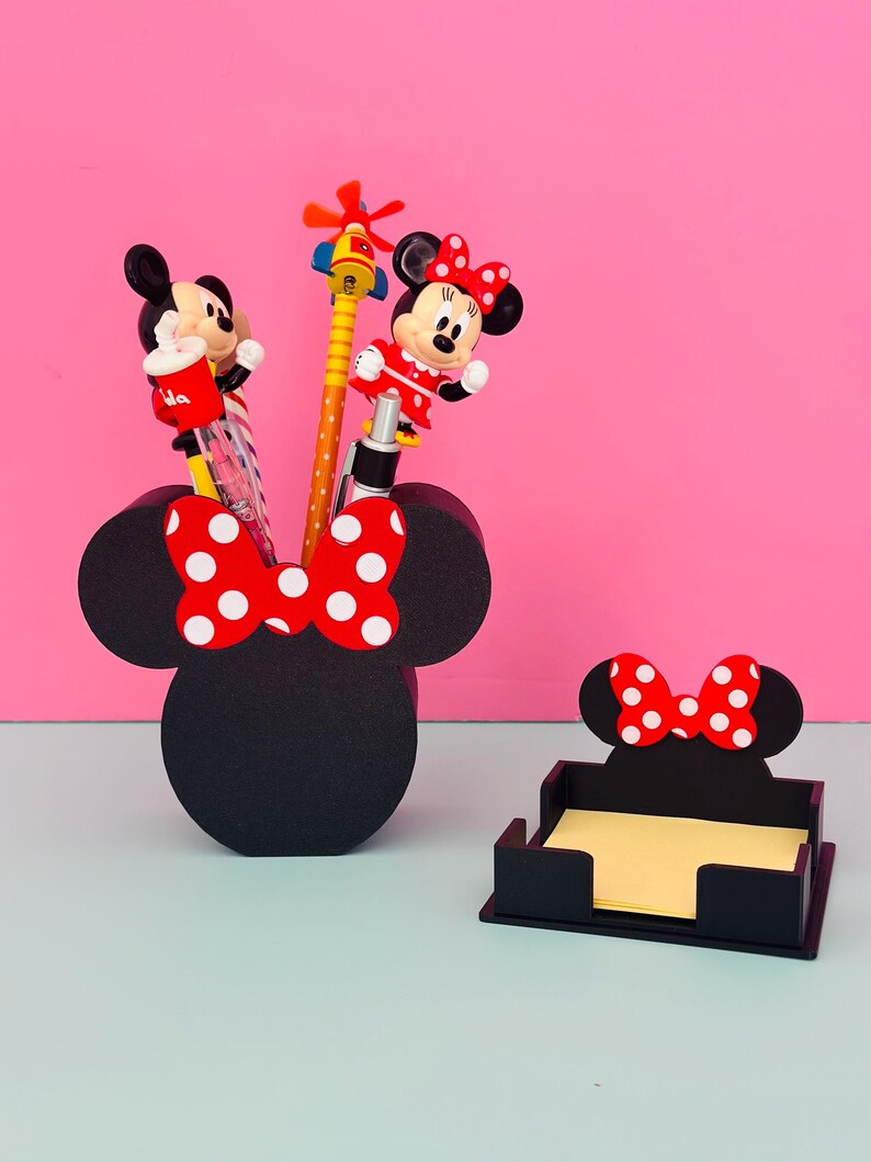 Puede incluir: Juego de organizador de escritorio negro con tem&aacute;tica de Minnie Mouse. El juego incluye un portal&aacute;pices con la silueta de Minnie y un lazo rojo con lunares blancos, y un portabloques de notas. El portal&aacute;pices contiene bol&iacute;grafos con adornos de personajes de dibujos animados.