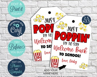 May include: Two printable gift tags with a popcorn theme. The tags are white with red and black text. The text says "Just Poppin' by to say Welcome Back to School!" and includes space to add a name. The tags are 2.5 inches by 3.5 inches.