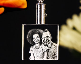 May include: A crystal keychain with a black and white engraved image of a father and daughter smiling at the camera.