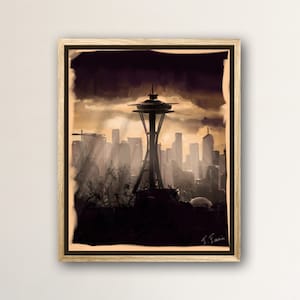 May include: A framed print of a black and white illustration of the Seattle Space Needle and the city skyline. The illustration has a vintage, faded look.