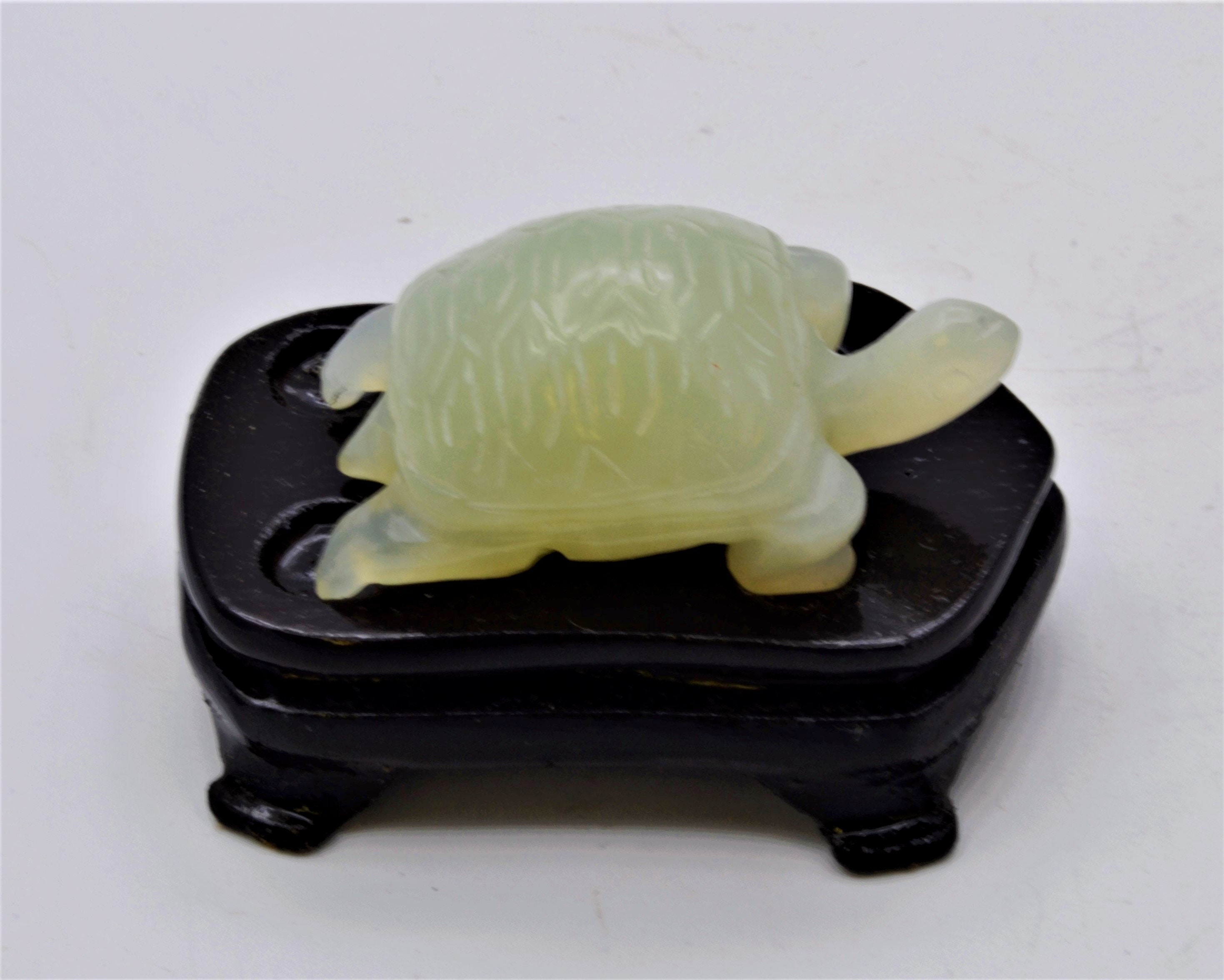 スタンドに置かれたヴィンテージの手作りカメ。細部までこだわった翡翠