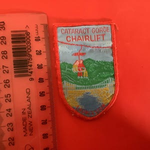 Könnte beinhalten: Eine weiße Keramik-Tasse mit schwarzem Henkel und dem Text "But First, Coffee" in handschriftlichem Stil. Die Tasse steht auf einer weißen Oberfläche. Die Tasse ist etwa 10 cm hoch.