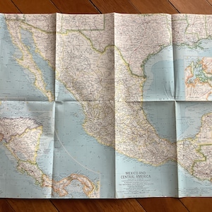 May include: A vintage map of Mexico and Central America, printed by the National Geographic Society. The map shows the countries of Mexico, Guatemala, Belize, Honduras, El Salvador, Nicaragua, Costa Rica, and Panama. The map is folded and has a blue background with brown lines and text.