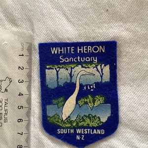 May include: Blue felt patch with white heron illustration and text "WHITE HERON Sanctuary SOUTH WESTLAND N-Z"