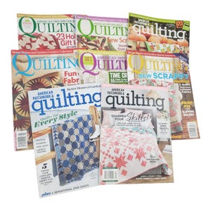 Puede incluir: Una pila de revistas "American Patchwork & Quilting". Las portadas presentan diseños de edredones coloridos, temas de temporada y artículos sobre técnicas de acolchado. Los títulos incluyen "Quilts for Every Style" y "Sharpen Your Skills!"