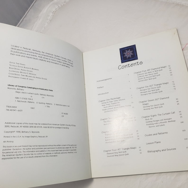 Puede incluir: Un libro titulado "Magic Stack-n-Whack Quilts" de Bethany Reynolds. La portada del libro presenta una colcha azul y blanca con un patr&oacute;n de diamante. El libro trata sobre el acolchado e incluye instrucciones para hacer diferentes tipos de acolchados.