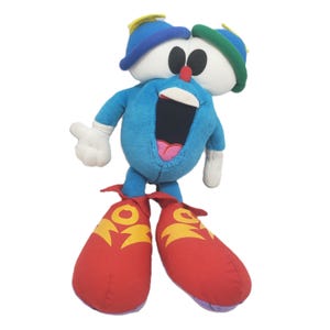 May include: A plush toy in the shape of a cartoon character. The character has a blue body, white hands, and red shoes. The head has two large white eyes, a red nose, and a blue hat. The mouth is open, revealing a pink interior.