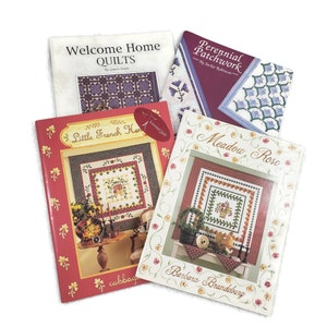 May include: Four quilting pattern books with colourful covers. The titles are "Welcome Home Quilts", "Perennial Patchwork", "Little French Hen", and "Meadow Rose".
