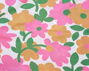 May include: A white fabric with a repeating pattern of pink, orange, and green flowers. The flowers are stylized and have a retro 1960s or 1970s feel.