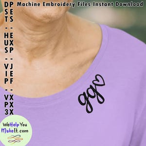 May include: A purple shirt with a black embroidered design that says "goo" with a heart above the "o".