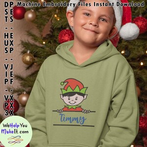 Peut inclure: Un sweat à capuche vert avec un motif d'elfe de dessin animé et le nom "Timmy" imprimé dessus. L'elfe regarde par-dessus une pancarte avec le nom.