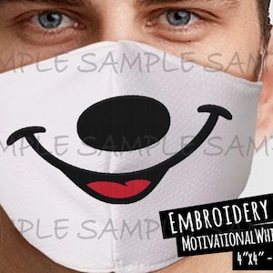 May include: White face mask with a black nose and red smiling mouth. The mask is embroidered with a Mickey Mouse design. The text "EMBROIDERY FILE" and "MOTIVATIONAL WHIMSY.COM" is printed on a black rectangle at the bottom of the image. The text "4"x4" - 10x10CM" is printed below the website address.