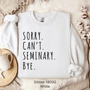 Op de afbeelding: Wit sweatshirt met de tekst "Sorry. Can't. Seminary. Bye." gedrukt op de voorkant. Het sweatshirt is gemaakt door Gildan en is maat 18000.