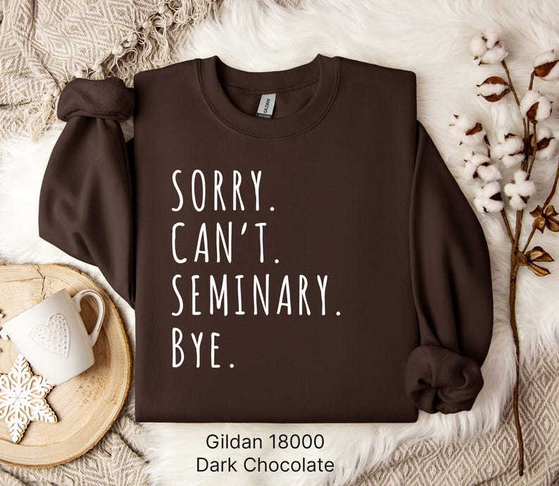 Op de afbeelding: Een donkerbruin sweatshirt met de tekst "Sorry. Can't. Seminary. Bye." in witte letters. Het sweatshirt is gemaakt door Gildan en is maat 18000.