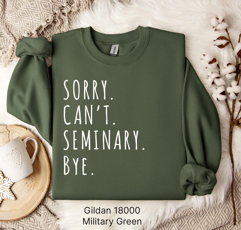 Op de afbeelding: Een groen Gildan 18000 sweatshirt met de tekst "Sorry. Can't. Seminary. Bye." in wit gedrukt.