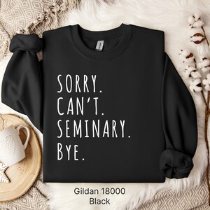 Op de afbeelding: Zwart sweatshirt met de tekst "Sorry. Can't. Seminary. Bye." in witte letters. Het sweatshirt is een Gildan 18000.