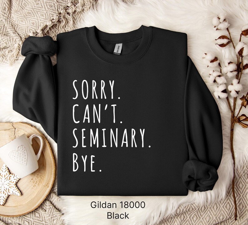 Op de afbeelding: Zwart sweatshirt met de tekst "Sorry. Can't. Seminary. Bye." in witte letters. Het sweatshirt is een Gildan 18000.