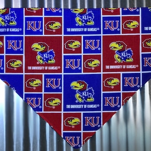 May include: A red and blue bandana with a repeating pattern of the University of Kansas Jayhawk mascot and the letters "KU".