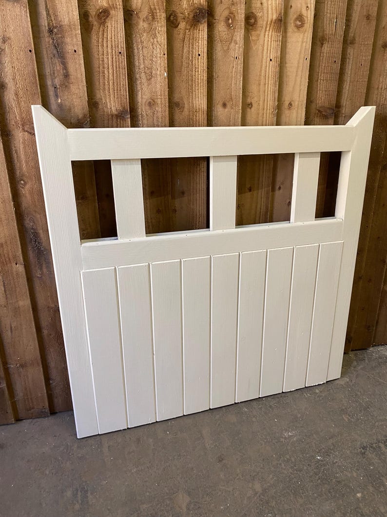 May include: White wooden gate with a slatted design and a decorative top. The gate has four rectangular openings in the top section.