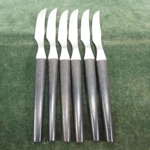 May include: Six silver dinner knives with black wooden handles.