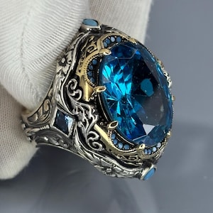 Gloved side-angle close-up showing intricate scroll engravings and the aquamarine stone in a Turkish handmade 925 sterling silver band.