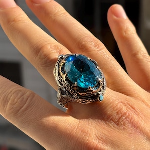 On-hand photo with fingers extended showing the aquamarine men’s statement ring and its bold, chunky presence.