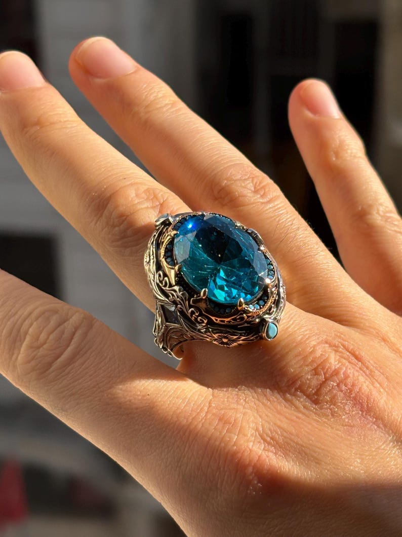 On-hand photo with fingers extended showing the aquamarine men’s statement ring and its bold, chunky presence.