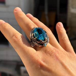 On-hand lifestyle photo showing how the aquamarine blue stone men’s ring looks when worn, with vintage Ottoman details visible.