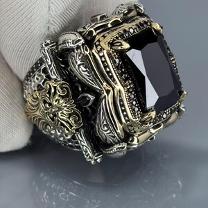 On-hand lifestyle photo showing the black onyx statement ring worn on finger with ornate vintage detailing visible.