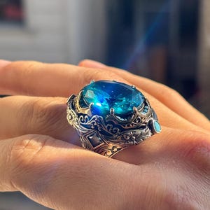 On-hand side close-up showing the elevated aquamarine stone setting and ornate Turkish handmade silver details.