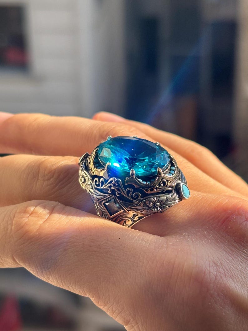 On-hand side close-up showing the elevated aquamarine stone setting and ornate Turkish handmade silver details.