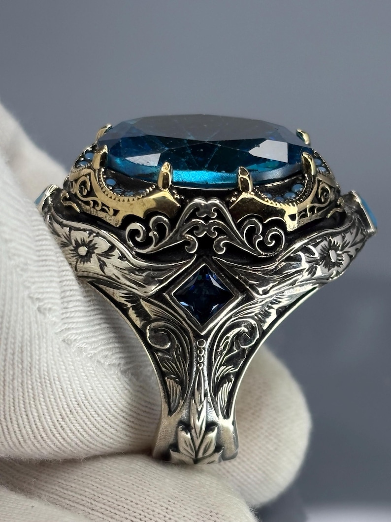 Gloved back/side view showing the band’s Ottoman-inspired scrollwork and sturdy 925 sterling silver construction beneath the aquamarine setting.