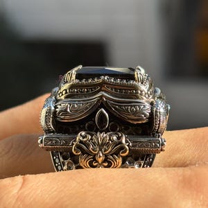On-hand close-up from the front showing the decorative top design and black onyx stone sparkle-free glossy finish.