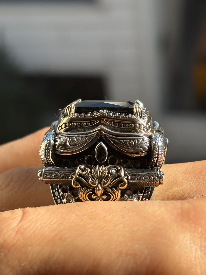 On-hand close-up from the front showing the decorative top design and black onyx stone sparkle-free glossy finish.