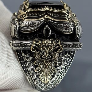 Gloved back/side view showing the Ottoman-inspired scrollwork and sturdy 925 sterling silver construction of the men’s ring.
